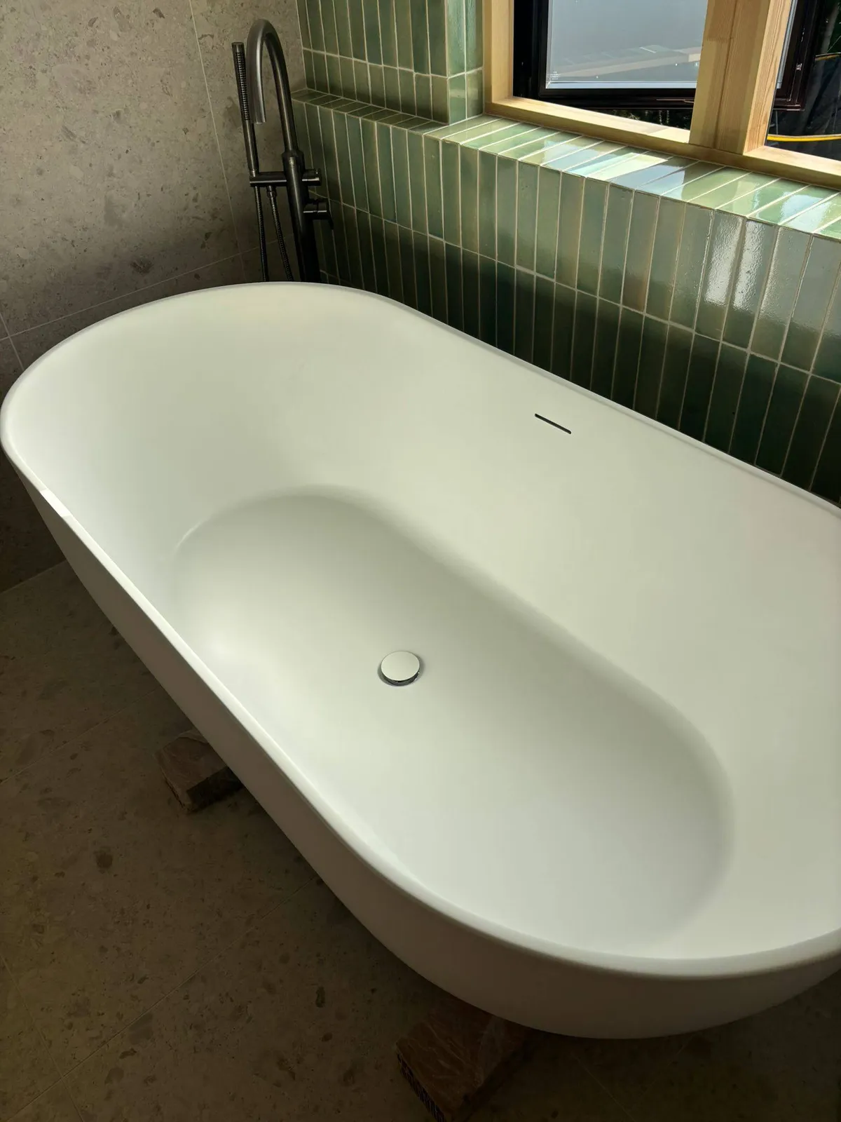A freestanding bath in a newly finished bathroom after a post-construction handover clean
