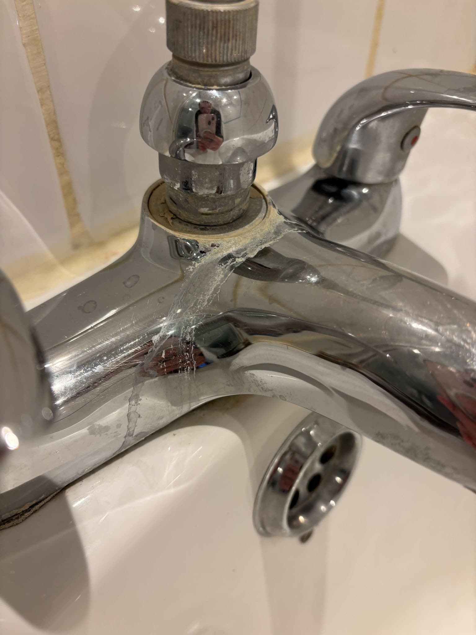 Chrome bath taps coated in heavy limescale and chalky water deposits