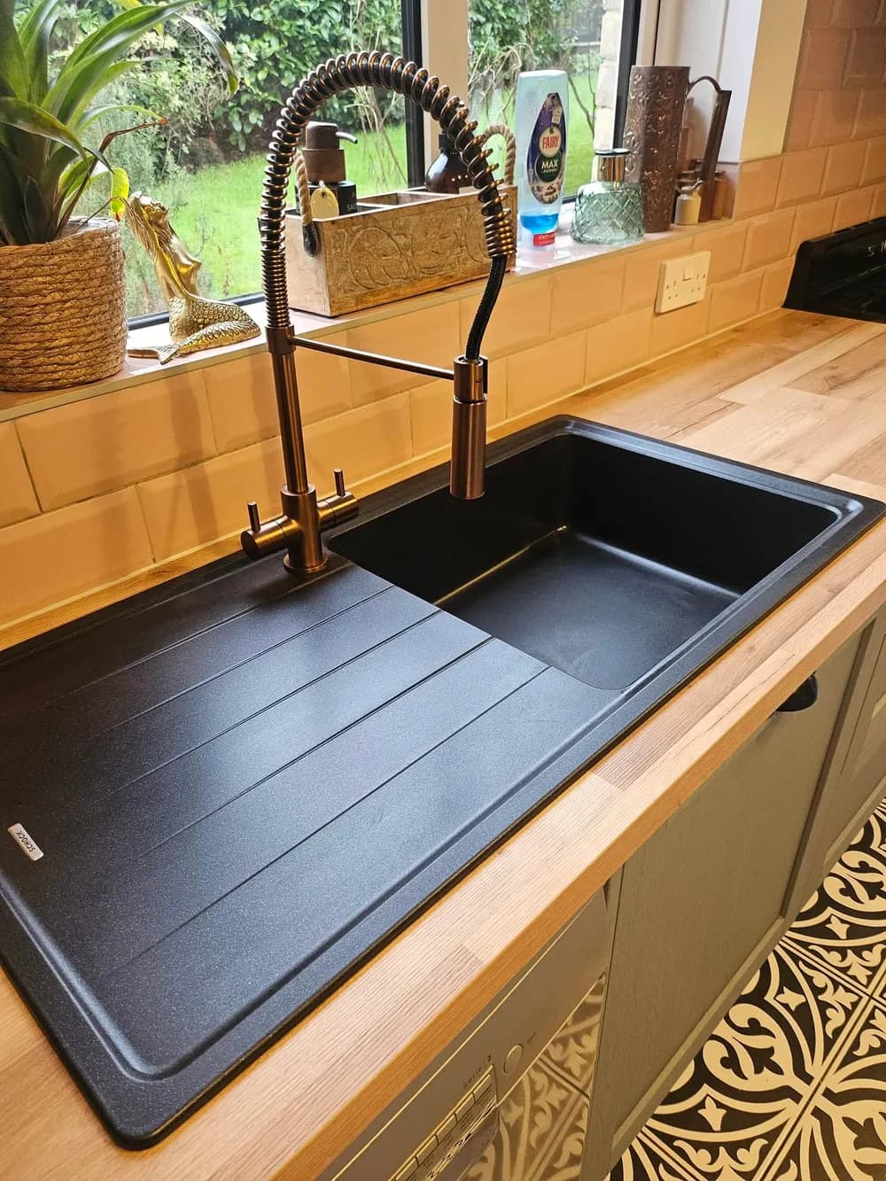A composite kitchen sink polished to a high-gloss finish